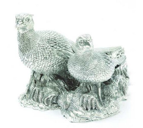 a medium sized silver figurine of a pair of pheasants